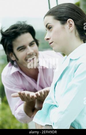 Mittlerer Erwachsener Mann flehend zu einer jungen Frau Stockfoto