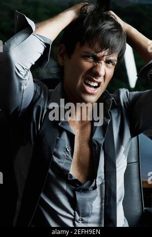 Porträt eines Geschäftsmannes, der vor Wut an den Haaren zieht Stockfoto