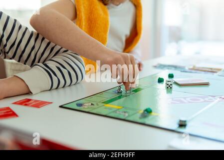 KIEL, DEUTSCHLAND - 14. Februar 2021: Hände mit Geld von glücklichen Kindern, die Spaß am Brettspiel in gemütlicher Familienzeit mit ihren Eltern haben Stockfoto