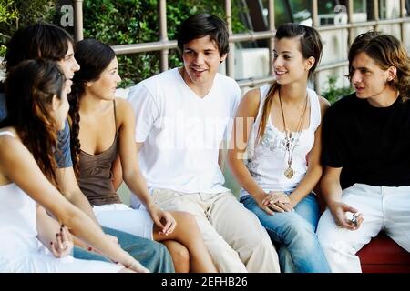 Gruppe von Freunden, die auf einer Kante sitzen Stockfoto