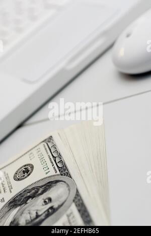 High-Angle-Ansicht eines Laptops mit hundert Dollar Rechnungen Stockfoto