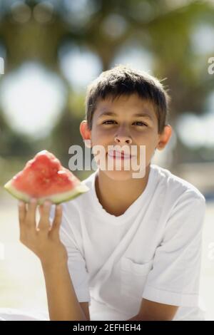 Porträt eines Jungen im Teenageralter, der eine Wassermelone hält Stockfoto