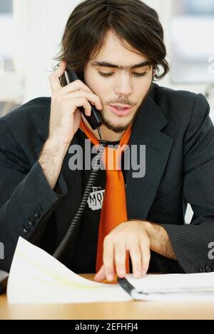 Nahaufnahme eines Geschäftsmannes, der am Telefon spricht und liest Eine Datei Stockfoto