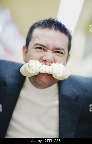 Porträt eines mittleren erwachsenen Mannes mit einem Hundeknochen In seinem Mund