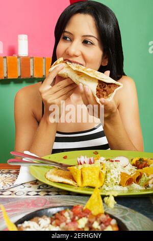 Nahaufnahme einer jungen Frau, die ein Wrap Sandwich isst Stockfoto