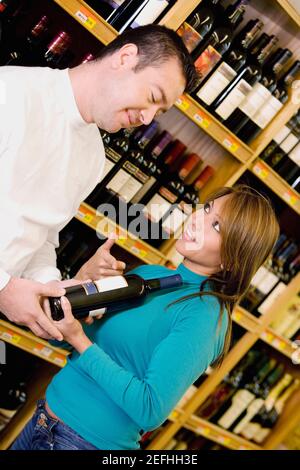 Junge Frau und ein Mann mittleren Erwachsenen im Weinladen Stockfoto