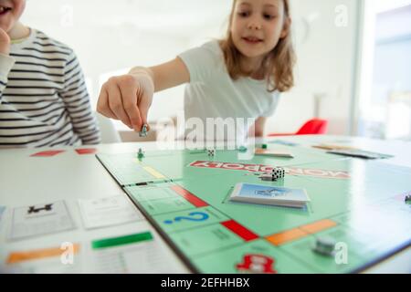 KIEL, DEUTSCHLAND - 14. Februar 2021: Fröhliche Kinder, die gemeinsam mit ihren Eltern Spaß am Brettspiel haben Stockfoto