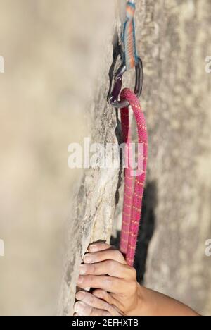 Nahaufnahme einer climberÅ½s Hände, die einen Felsen greifen Stockfoto