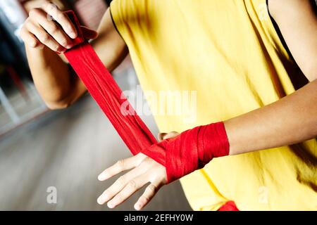 Mittelansicht eines männlichen Boxers, der seine Hand umwickelt Mit einem Verband Stockfoto