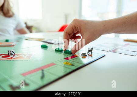 KIEL, DEUTSCHLAND - 14. Februar 2021: Hände mit Geld von glücklichen Kindern, die Spaß am Brettspiel in gemütlicher Familienzeit mit ihren Eltern haben Stockfoto