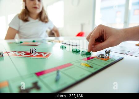 KIEL, DEUTSCHLAND - 14. Februar 2021: Hände mit Geld von glücklichen Kindern, die Spaß am Brettspiel in gemütlicher Familienzeit mit ihren Eltern haben Stockfoto