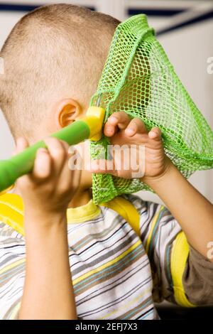 Nahaufnahme eines Jungen, der ein Schmetterlingsnetz hält Stockfoto