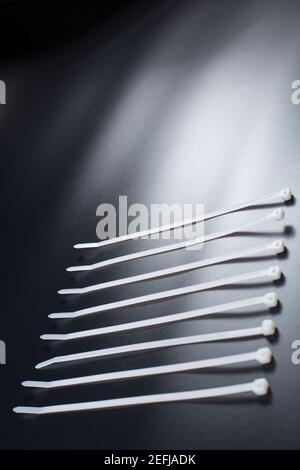 Weiße Kabelbinder auf schwarzem Hintergrund mit Kopierplatz. Stockfoto