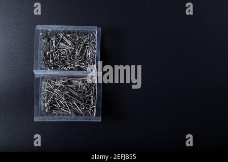 Metallnägel zwei verschiedene Größen in Boxen, auf schwarz mit Kopierraum. Stockfoto