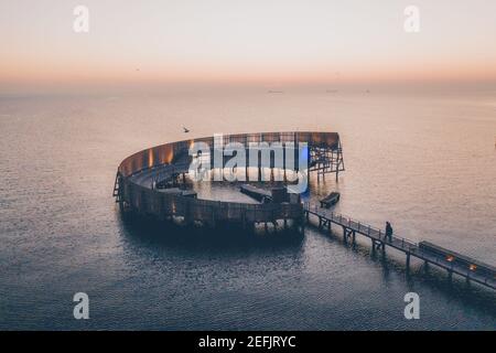 Kopenhagen, Dänemark - 27. Februar 2019. Sonnenuntergang über Kastrup Søbad (Kastrup Sea Bath) in Kopenhagen. Die Holzkonstruktion ist auch als Schnecke bekannt und wurde von White Architects entworfen. Stockfoto