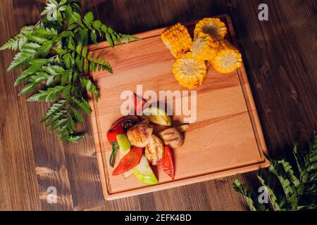 Hausgemachte Bio gegrilltem Sommergemüse auf rustikalen Tisch. Mais, Paprika, Zwiebeln, Auberginen, Zucchini. Vegetarische Kost-Konzept Stockfoto