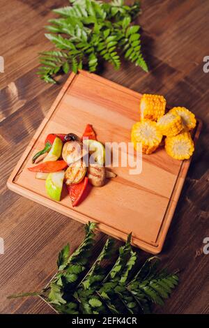 Hausgemachte Bio gegrilltem Sommergemüse auf rustikalen Tisch. Mais, Paprika, Zwiebeln, Auberginen, Zucchini. Vegetarische Kost-Konzept Stockfoto