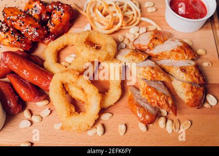 Große Auswahl an Snacks für Bier mit verschiedenen Soßen auf Pergament, Ansicht von oben Stockfoto