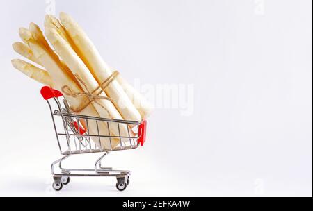 Weißer Spargel in einem Supermarkt-Trolley auf hellem Hintergrund. Weißer Spargel, Gemüse, gesundes Essen.frisch gepflückte rohe weiße Spargel aus biologischem Anbau b Stockfoto