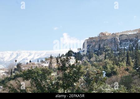 Athen, Griechenland - Februar 17 2021: Akropolis-Ansicht im Winter, mit Schnee in den Bergen Stockfoto