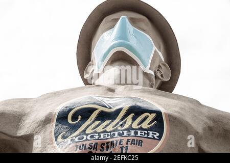 07 09 2020 Tulsa, USA Iconic Golden Driller - Riesenstatue des Ölfeldarbeiters in der Nähe der Route 66 in Oklahoma mit Harthut und Gesichtsmaske während der pande Stockfoto