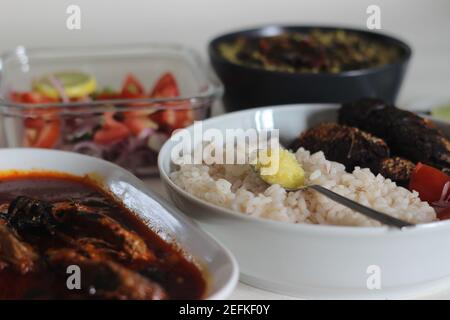 Kerala Mahlzeiten mit rotem Reis, Sardinen Curry, Sardinen braten und Kokosnuss-basierte grüne Gramm Curry. Alles im traditionellen kerala-Stil zubereitet Stockfoto