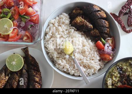 Kerala Mahlzeiten mit rotem Reis, Sardinen Curry, Sardinen braten und Kokosnuss-basierte grüne Gramm Curry. Alles im traditionellen kerala-Stil zubereitet Stockfoto