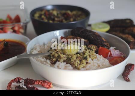 Kerala Mahlzeiten mit rotem Reis, Sardinen Curry, Sardinen braten und Kokosnuss-basierte grüne Gramm Curry. Alles im traditionellen kerala-Stil zubereitet Stockfoto