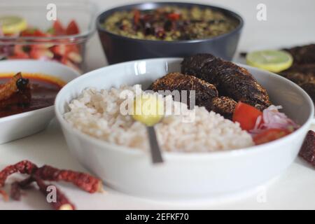 Kerala Mahlzeiten mit rotem Reis, Sardinen Curry, Sardinen braten und Kokosnuss-basierte grüne Gramm Curry. Alles im traditionellen kerala-Stil zubereitet Stockfoto