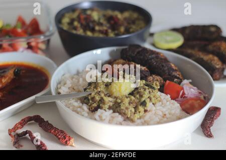 Kerala Mahlzeiten mit rotem Reis, Sardinen Curry, Sardinen braten und Kokosnuss-basierte grüne Gramm Curry. Alles im traditionellen kerala-Stil zubereitet Stockfoto