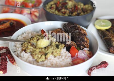 Kerala Mahlzeiten mit rotem Reis, Sardinen Curry, Sardinen braten und Kokosnuss-basierte grüne Gramm Curry. Alles im traditionellen kerala-Stil zubereitet Stockfoto