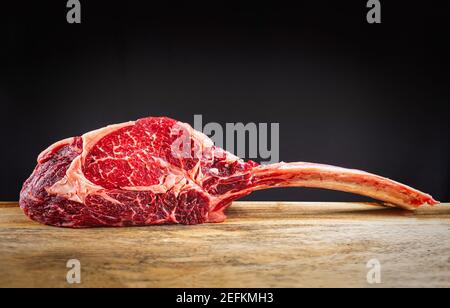 Trocken gealterte Wagyu Tomahawk Steak auf einem hölzernen Schneidebrett Stockfoto