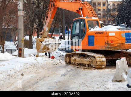 Ein großer Raupenbagger befreit die Straße von viel Schnee von einer Stadtstraße. Speicherplatz kopieren. Stockfoto