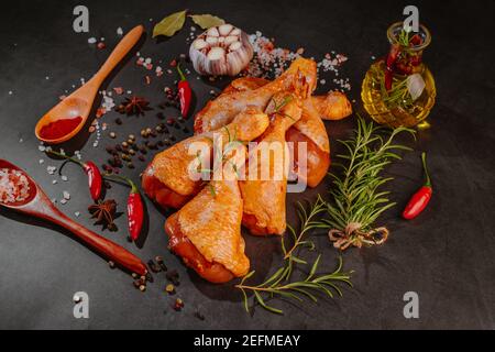 Rohe marinierte Hähnchendrumsticks mit Gewürzen bestreut, Chili-Stücke, Lorbeerblättern vorbereitet, um in einem Gericht zu kochen, Blick von oben.Drumstick mariniert Stockfoto