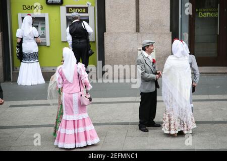 Menschen in traditioneller Madrileno-Kleidung warten an einem Bankautomaten in Madrid, Spanien. Allgemeine Ansichten in Madrid während des San Isidro Festivals 2016 Stockfoto