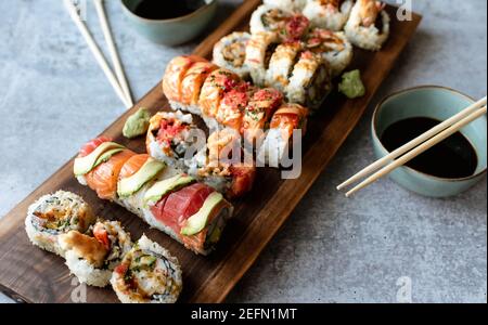 Overhead-Ansicht der Platte von Sushi-Rollen auf grauem Zement Hintergrund. Stockfoto