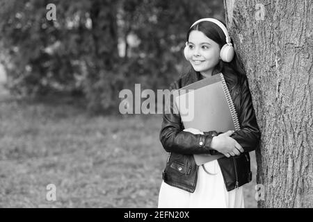 Mädchen hören Audio tragen Lehrbücher entspannende Park Hintergrund, Schulleben Konzept. Stockfoto