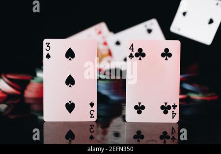 Poker-Karten mit Chips auf schwarzem Hintergrund Stockfoto