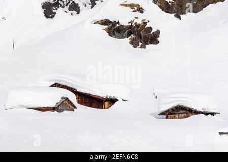 Holzhütten fast vollständig mit Schnee bedeckt nach einem Starker Schneefall in den europäischen Alpen Stockfoto