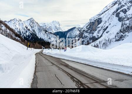 Gerade Strecke einer Straße in einem majestätischen schneebedeckten Berg Landschaft an einem bewölkten Wintertag Stockfoto