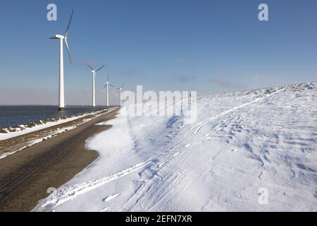 Reihen Sie Offshore-Windturbinen entlang Ductch Küste im Winter mit Schnee Stockfoto