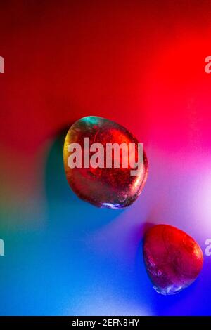 Zwei getaumelte Mineralsteine, bunt beleuchtet, mit abstrakten Details. Stockfoto