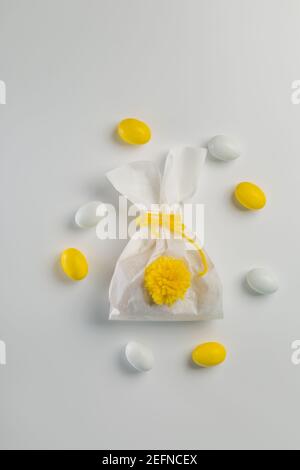 Osterkonzept - Hase geformte Tasche mit Eiern und Blumen auf hellgelbem Hintergrund, Stockfoto