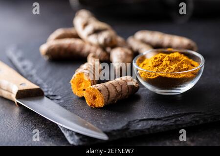 Indische Kurkuma Pulver und Wurzel. Kurkuma-Gewürz. Kurkuma in Schüssel gemahlen. Stockfoto
