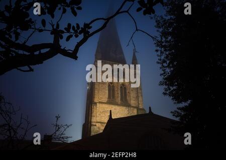 Die Chesterfield Crooked Spire of St Marys Kirche erleuchtet Beleuchtet am Abend blaue Stunde in der Nacht mit Nebel und Silhouette von Bäumen Derbyshire Stockfoto