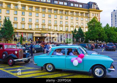 Jugendliche Schulabgänger in eleganten Ballkleid und Kostümen gekleidet Kommen mit Autos zum Restaurant für die Abschlussball Tag Party, Plovdiv, Bulgarien Stockfoto