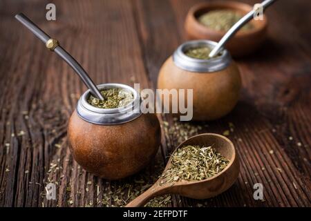 Gesundes Getränk, klassischer Yerba Mate Tee in einem Kürbis mit Mobilla auf Holzhintergrund Stockfoto