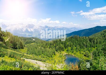 Magische idyllische Landschaft mit See in Bergen in Alpen Europa. Wanderweg auf grünen Hügeln in Alpen. Schöne Felsen und bewundern Sie erstaunliche Aussicht auf Berggipfel. Fantastischer sonniger Tag ist im Bergsee Stockfoto