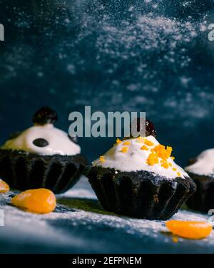 Schokoladen-Muffins bestreut mit Leckereien mit Kirschen und Schokolade und Kakao Stockfoto