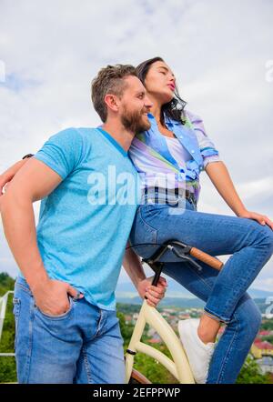 Mädchen mag er reitet ihr am Lenker. Mädchen sitzen am Lenker seines Fahrrades. Man bärtige macho Fahrten Freundin auf seinem Fahrrad. Idee für ein romantisches Date mit dem Fahrrad. Warum Frauen mehr angezogen biker Jungs. Stockfoto